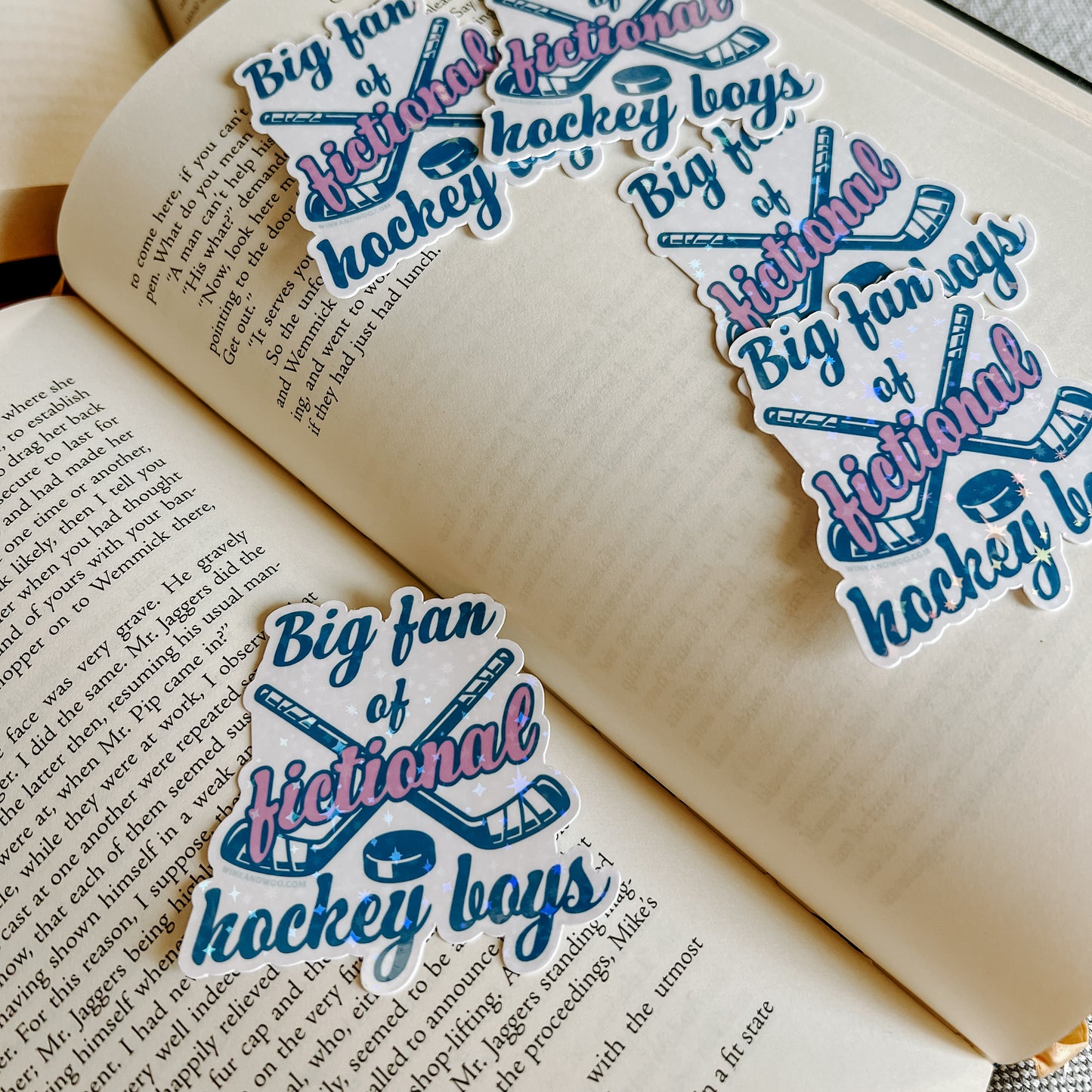 Stickers with 'Big fan of fictional hockey boys' text on an open book