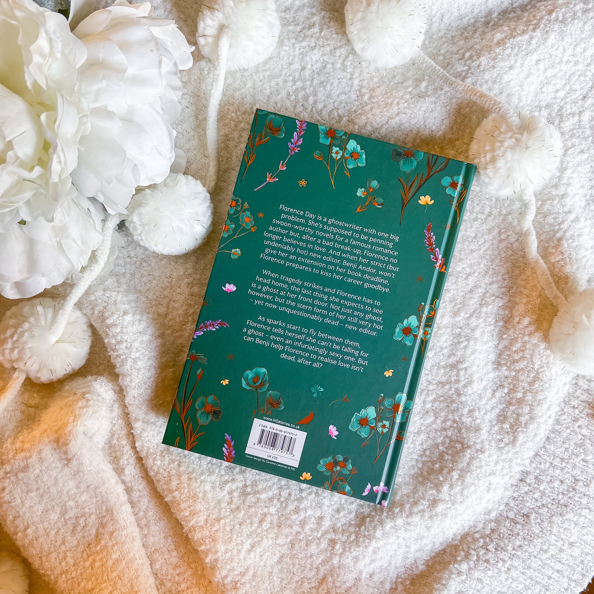 Book with floral design on a textured surface with white flowers