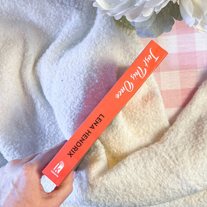 Lena Hendrix book spine held by a hand with a soft, textured background