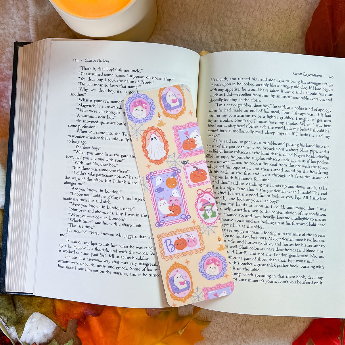 A handmade paper bookmark featuring cartoon ghosts and the attached to the right page.