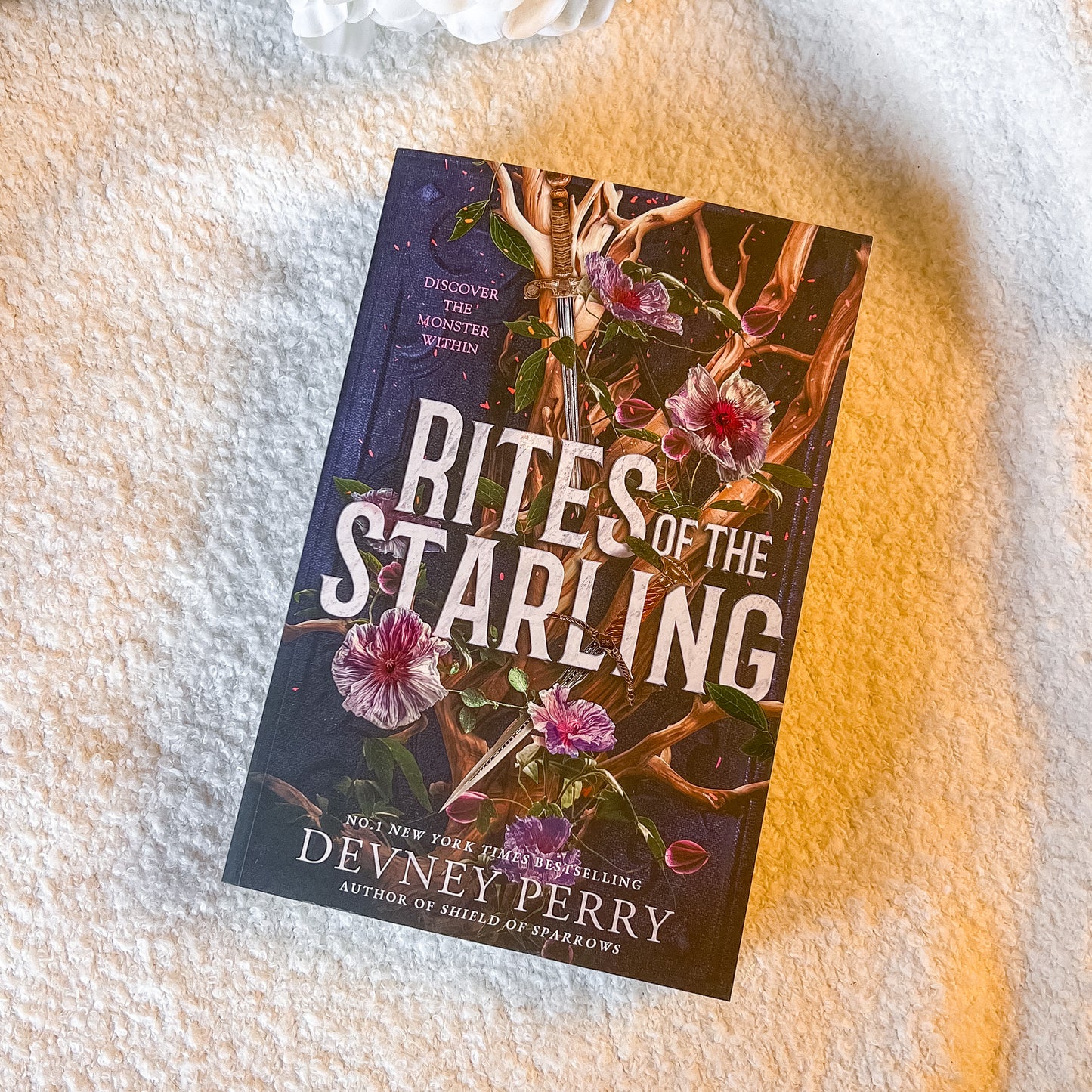 A book "Rites of the Starling" on a textured white surface.