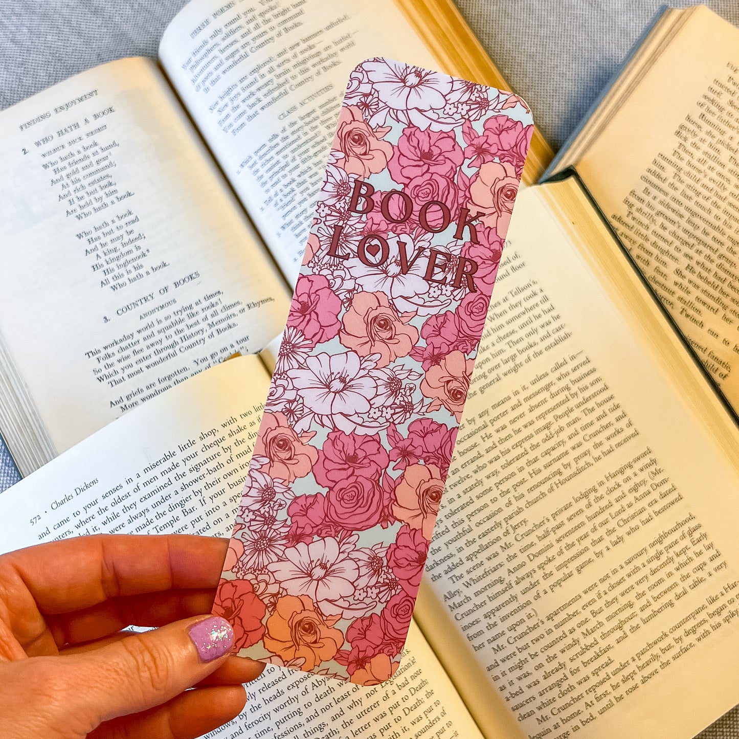 Floral bookmark with 'Book Lover' text held over an open book