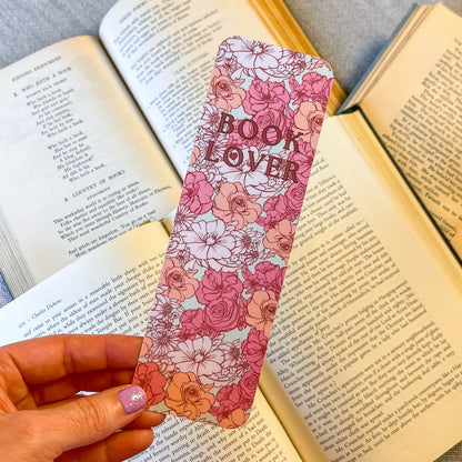 Floral bookmark with 'Book Lover' text held over an open book