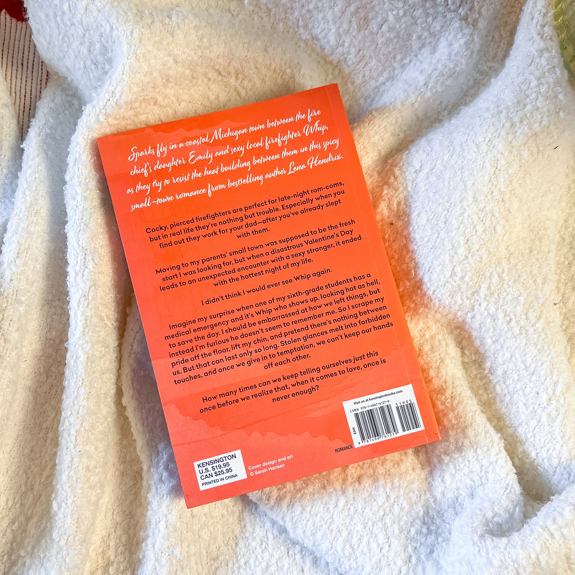 Book with orange back cover on a white blanket