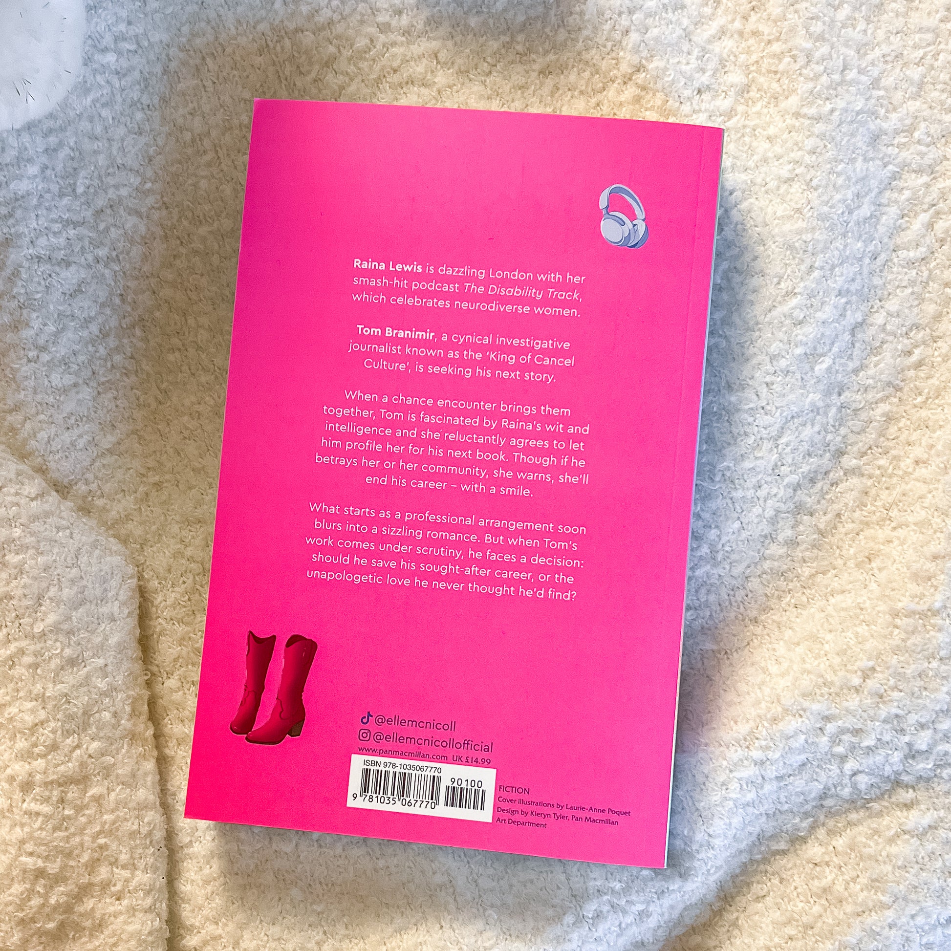 Pink book cover with text and red boots illustration on a textured surface