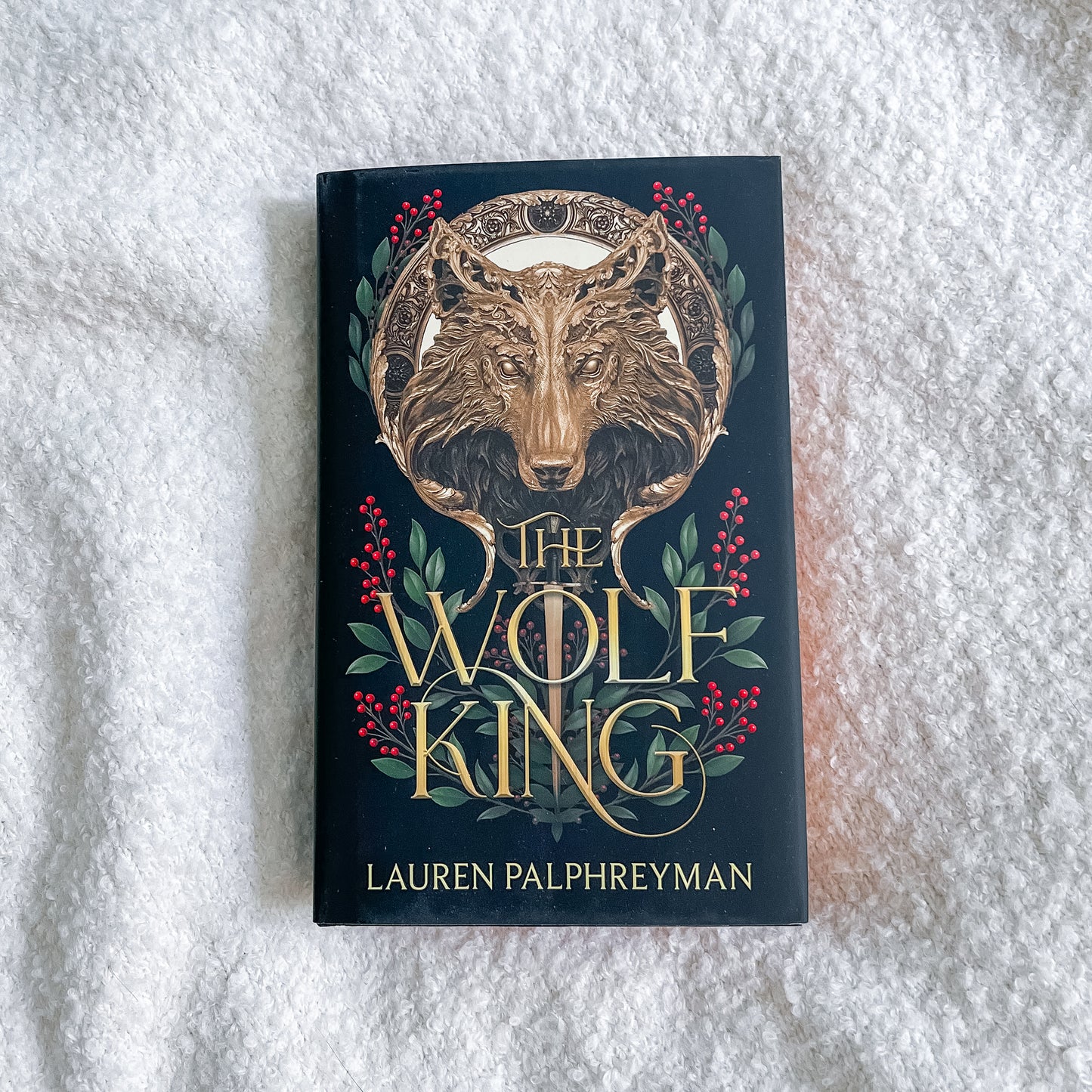 Book titled 'The Wolf King' by Lauren Palphreyman on a textured white surface