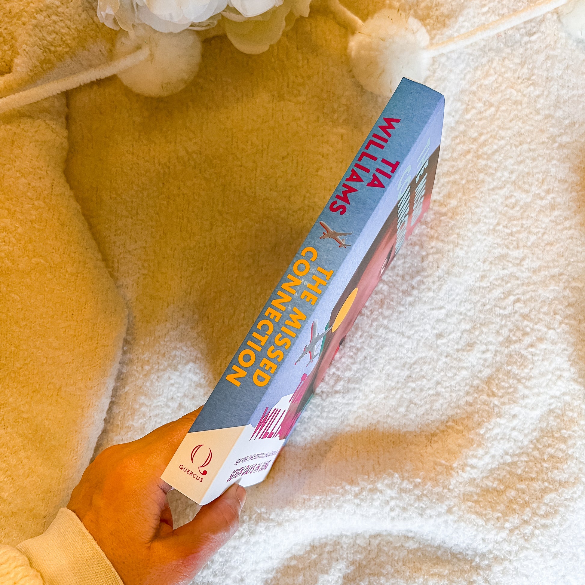 Book titled 'The Unmissable Connection' by Julia Williams held against a soft, textured background.
