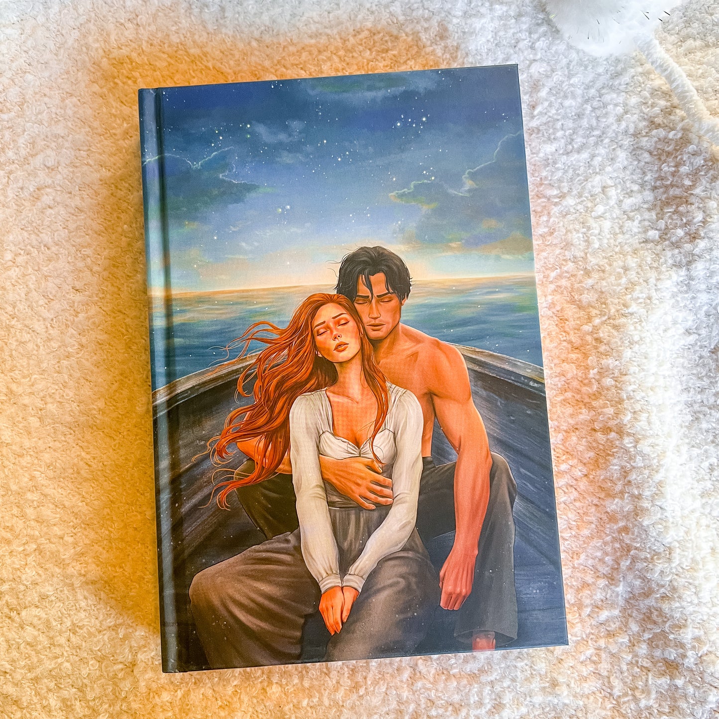 Book cover with an illustration of a couple on a boat against a sunset sky.