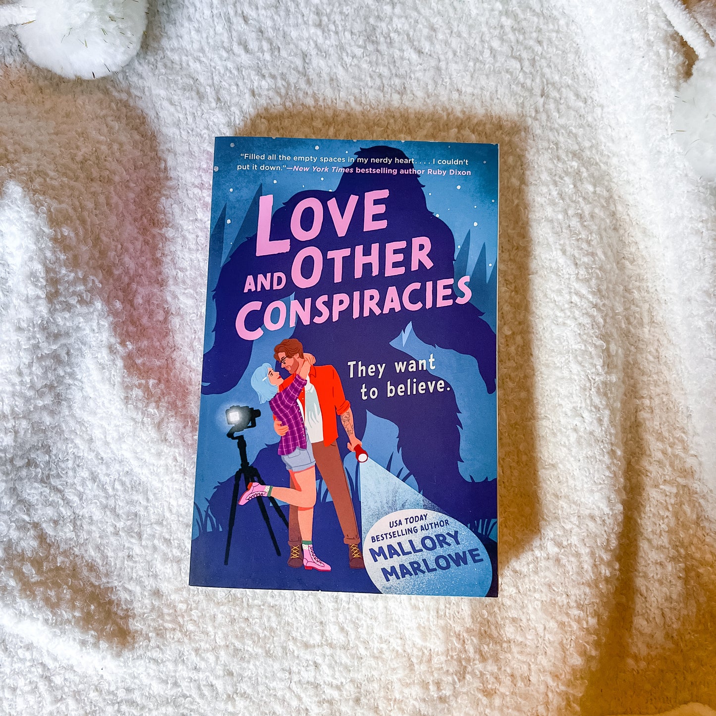Book titled 'Love and Other Conspiracies' on a textured surface