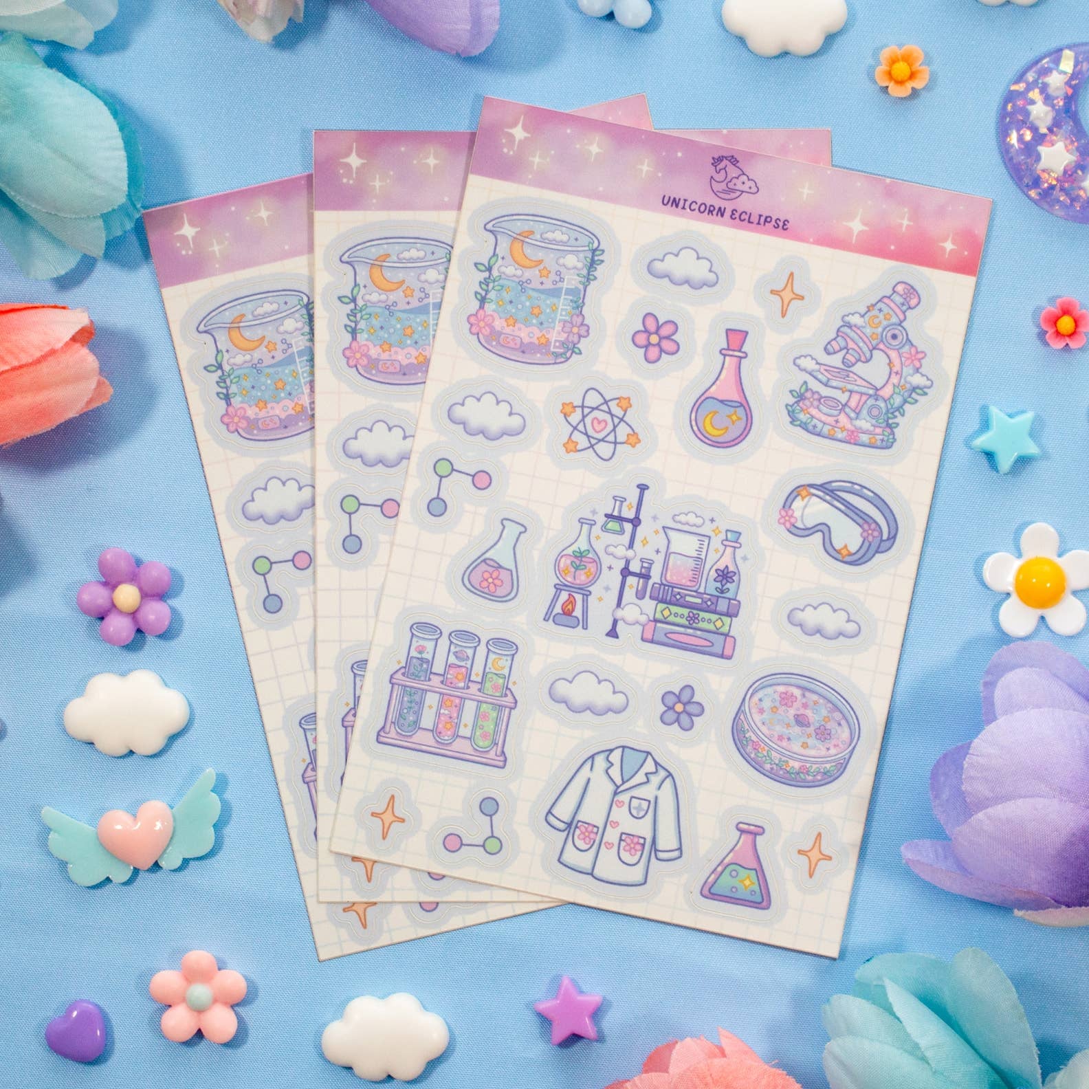 Sticker sheets with science-themed designs on a blue background with decorative elements.