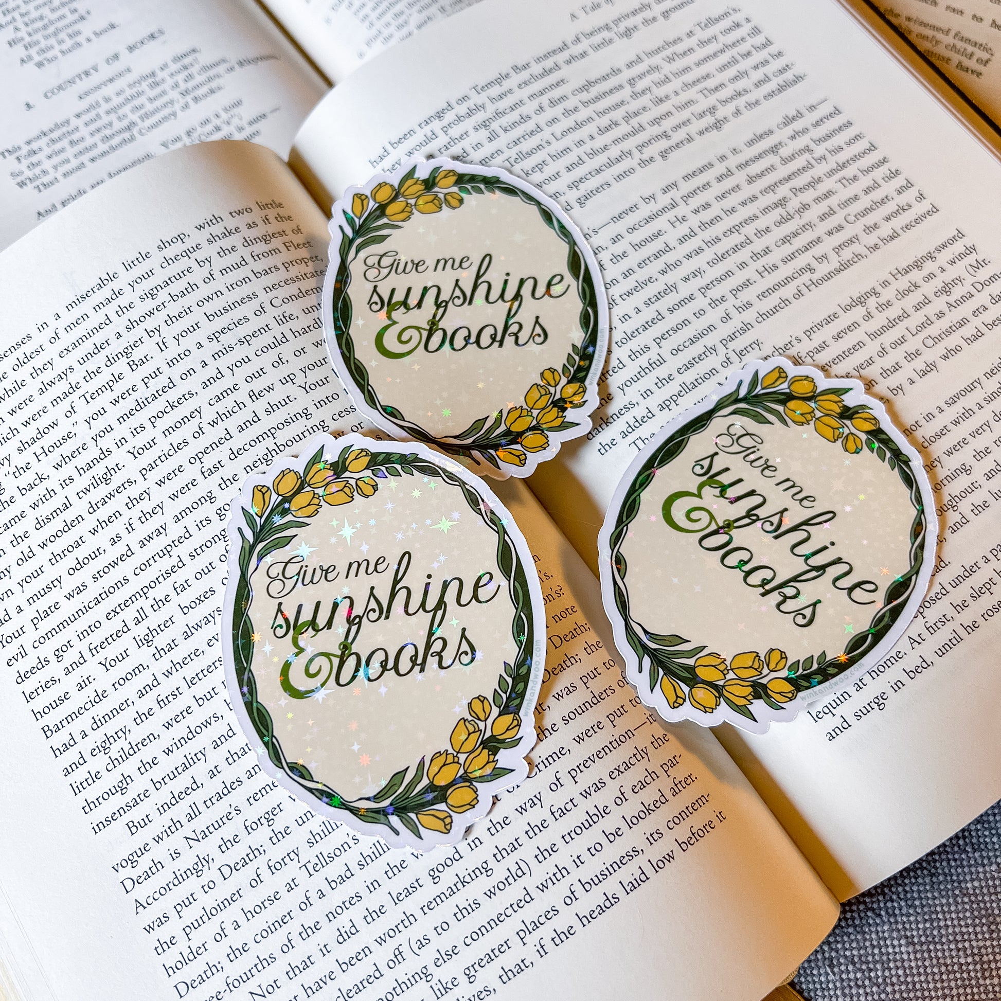 Three 'Give me sunshine books' stickers on an open book