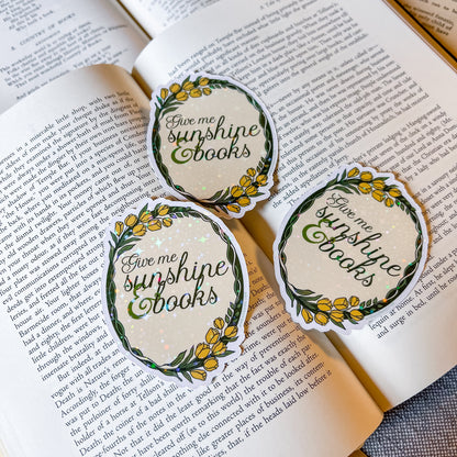 Three 'Give me sunshine books' stickers on an open book