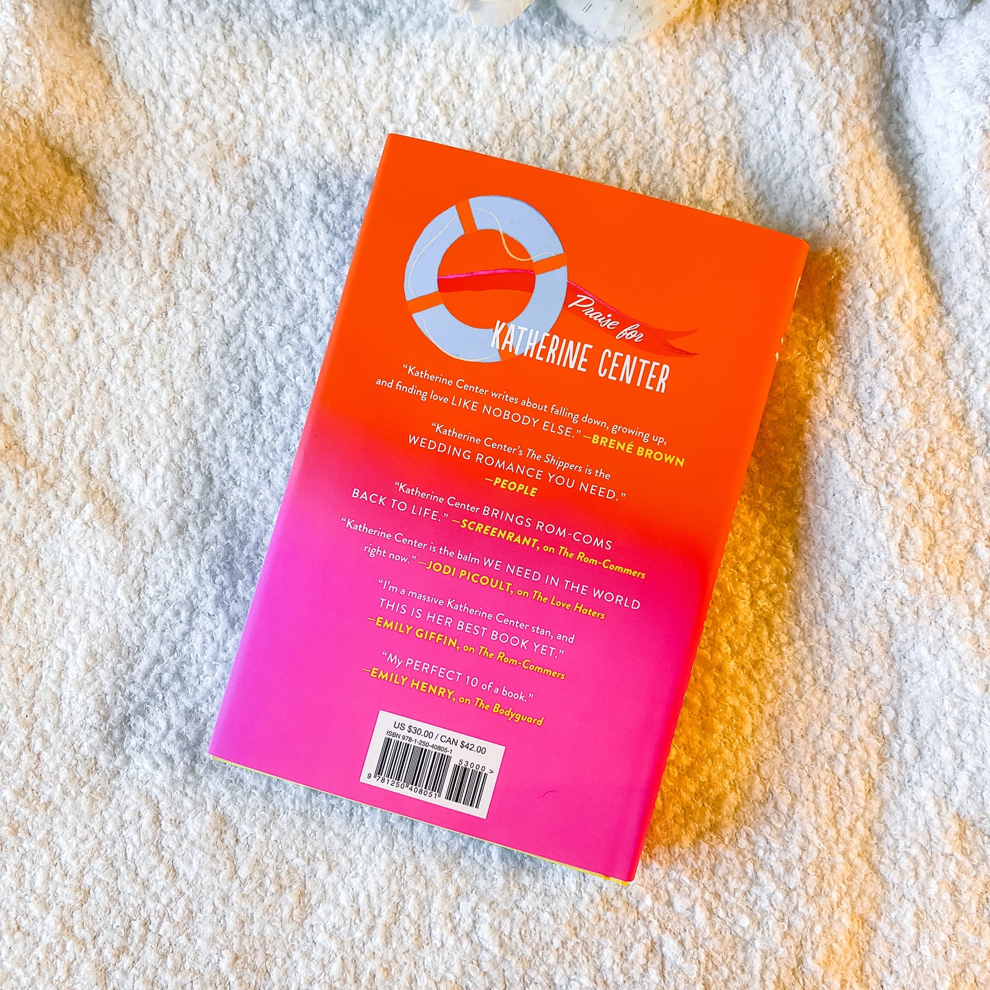 Book with a pink and orange cover on a textured surface