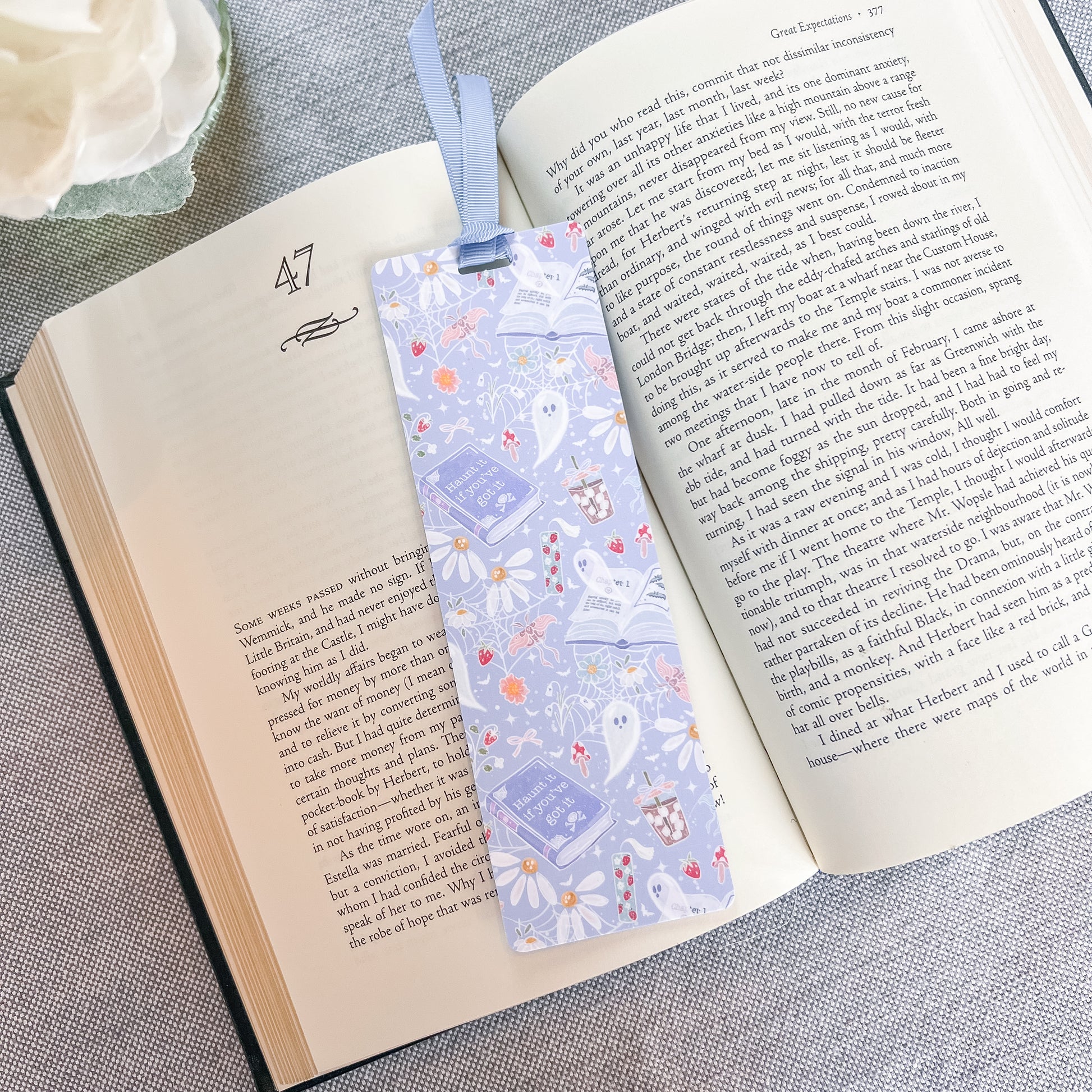 Blue bookmark with a ghost design on top of a book