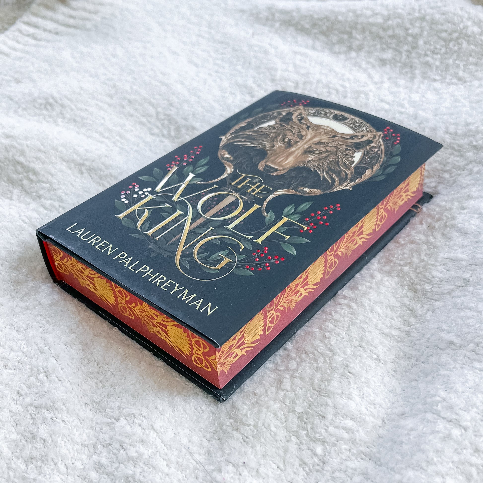 Book titled 'The Wolf King' by Lauren Palphreyman on a textured white surface