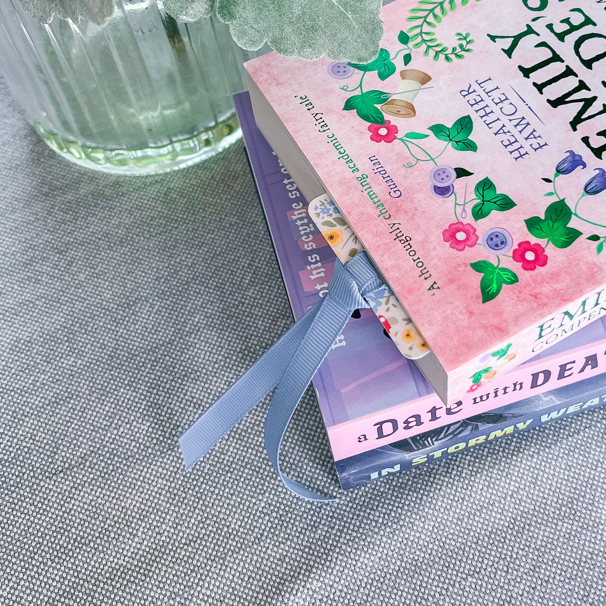 Floral bookmark with a blue ribbon tucked into a book.
