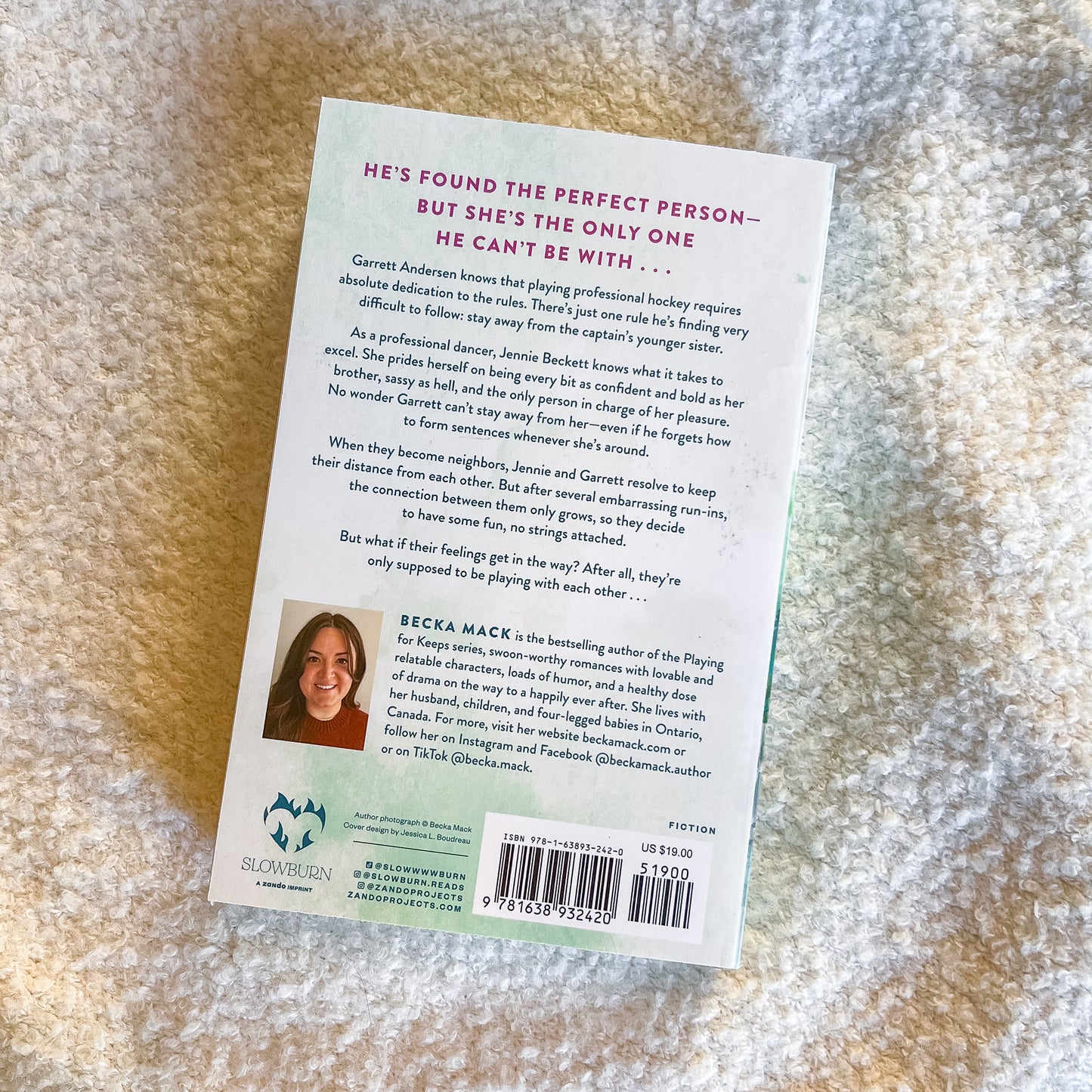Book back cover with text and a photo of a woman on a textured surface