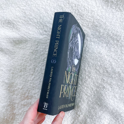 Book titled 'The Night Prince' by Lauren Palpireman held against a textured white background