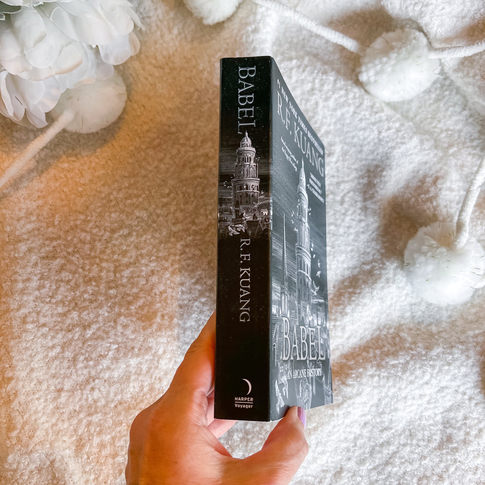 A hand holds a copy of the book 'Babel' by R. F.