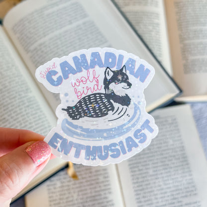 Sticker with a wolf design and text held over an open book