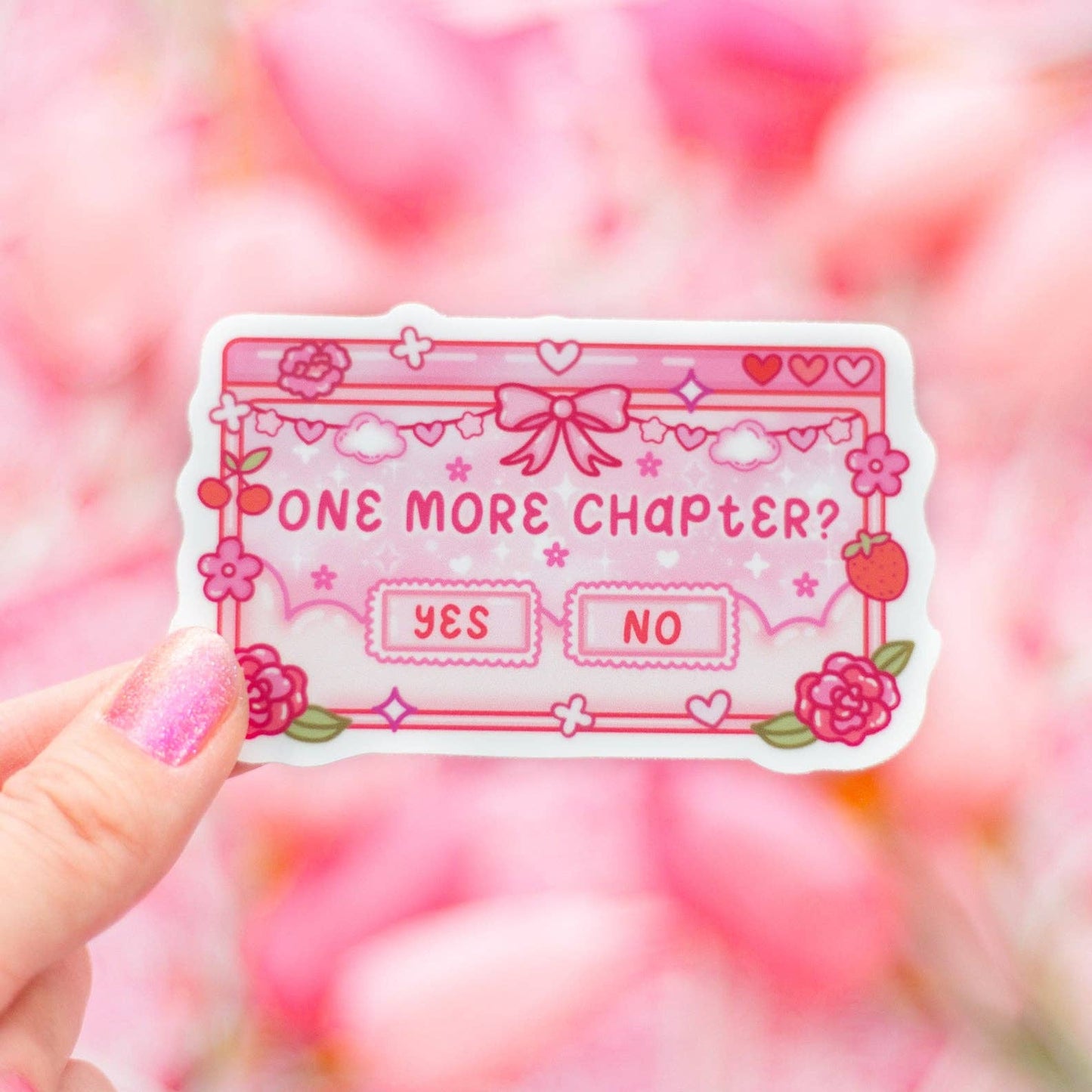 Pink sticker with 'One more chapter?' text held against a blurred pink floral background