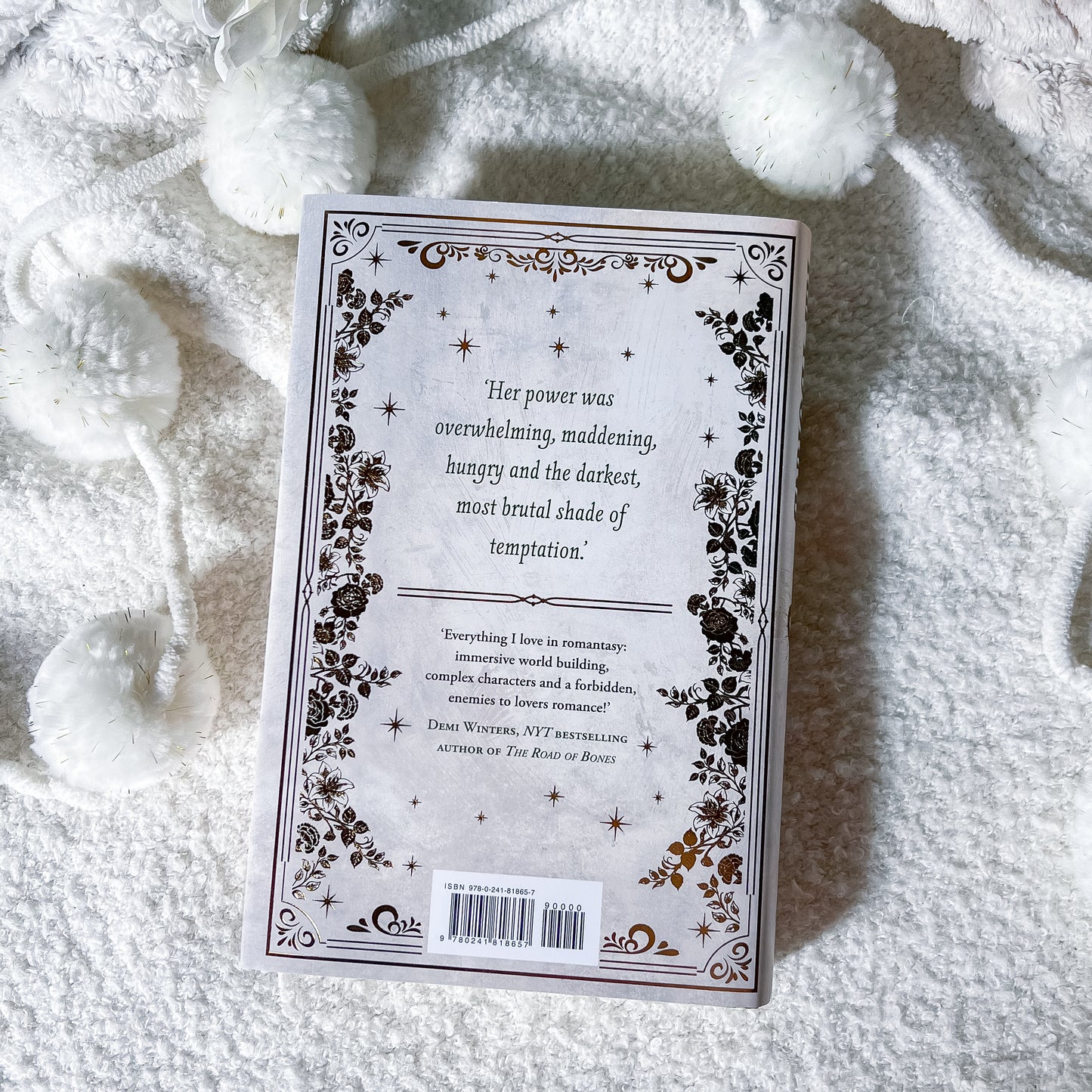 Book cover with decorative text and patterns on a textured white surface