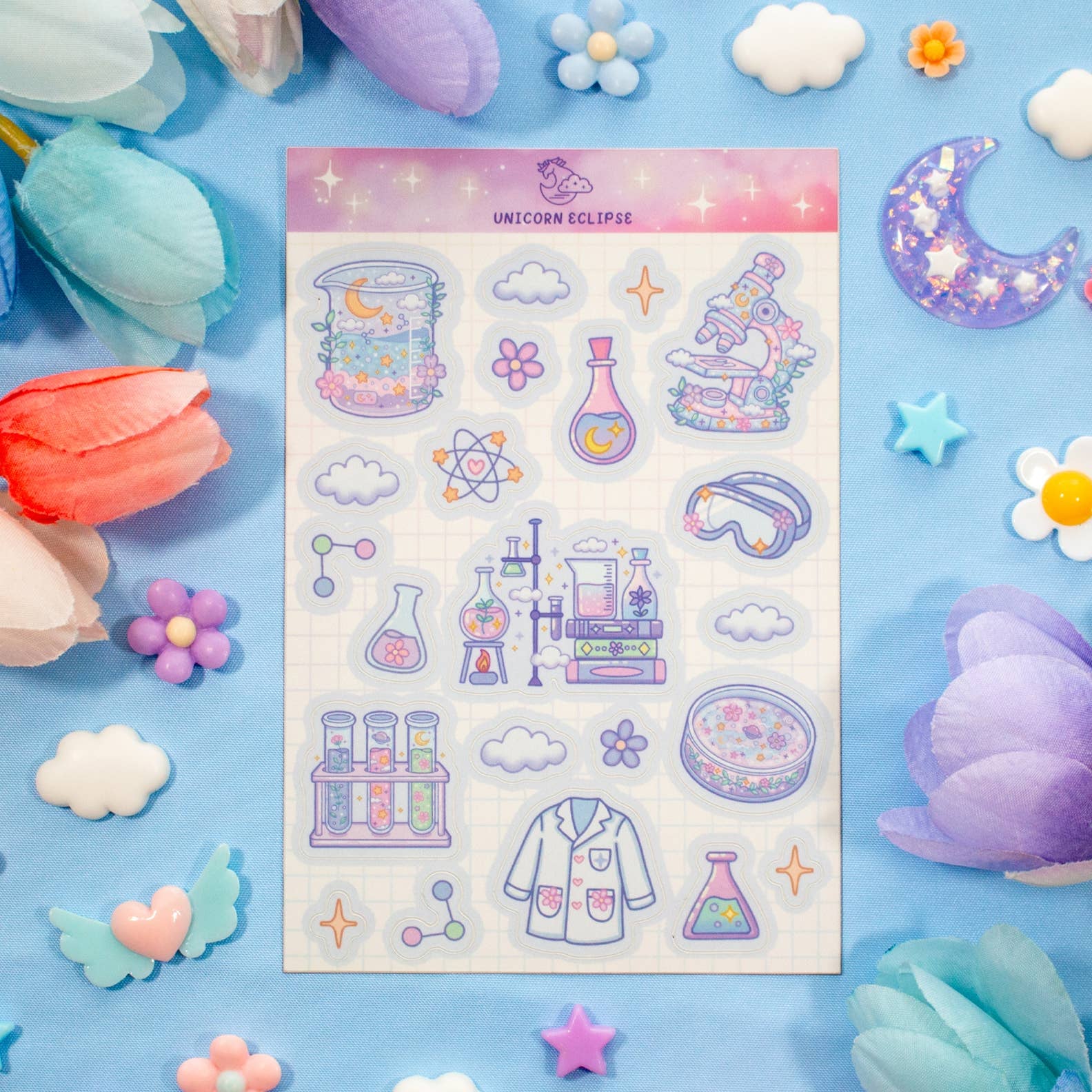 Sheet of colorful stickers with science-themed designs on a blue background with decorative elements.
