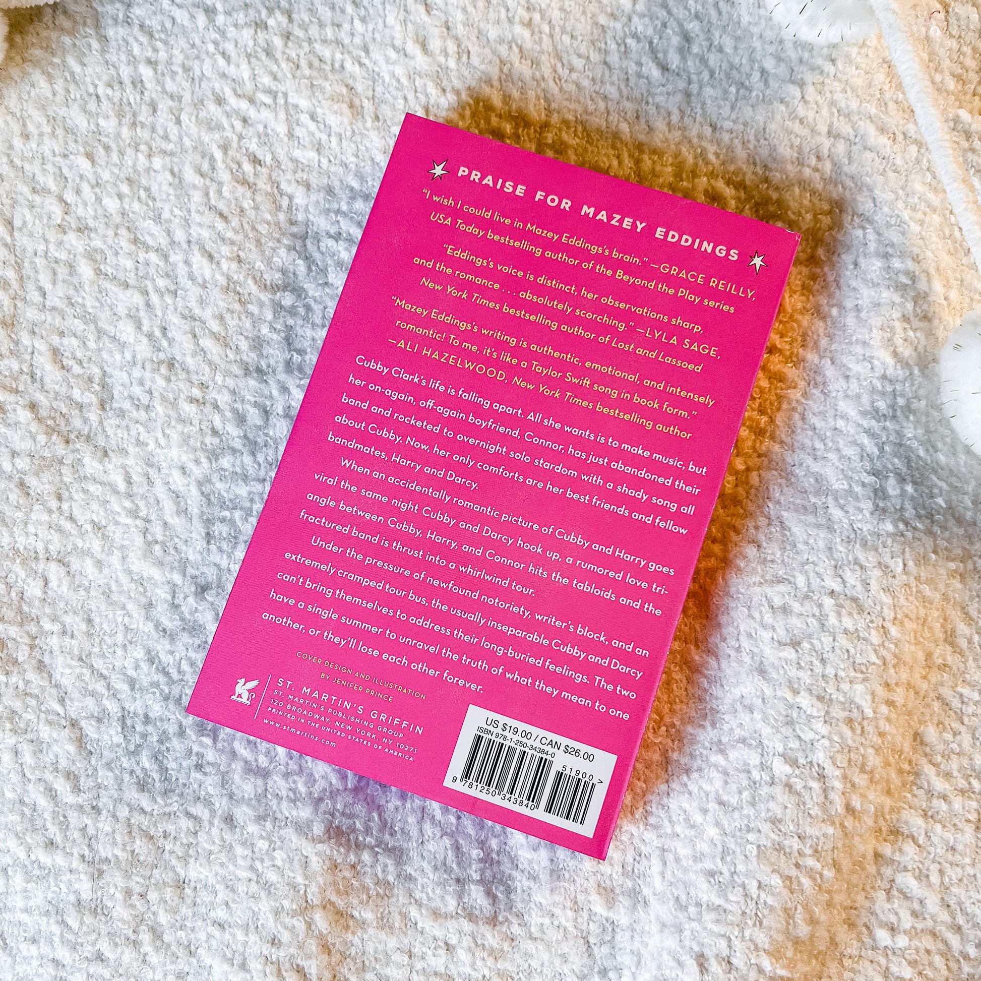 Back cover of a book with pink background and text on a textured surface