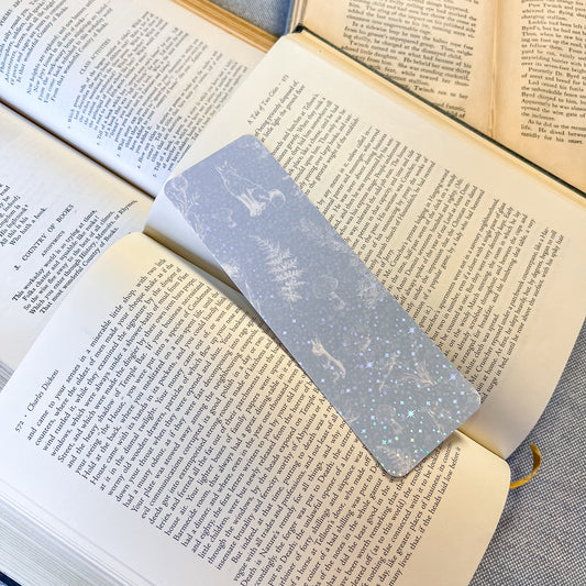 Open book with a decorative bookmark featuring a fox design on a textured surface.