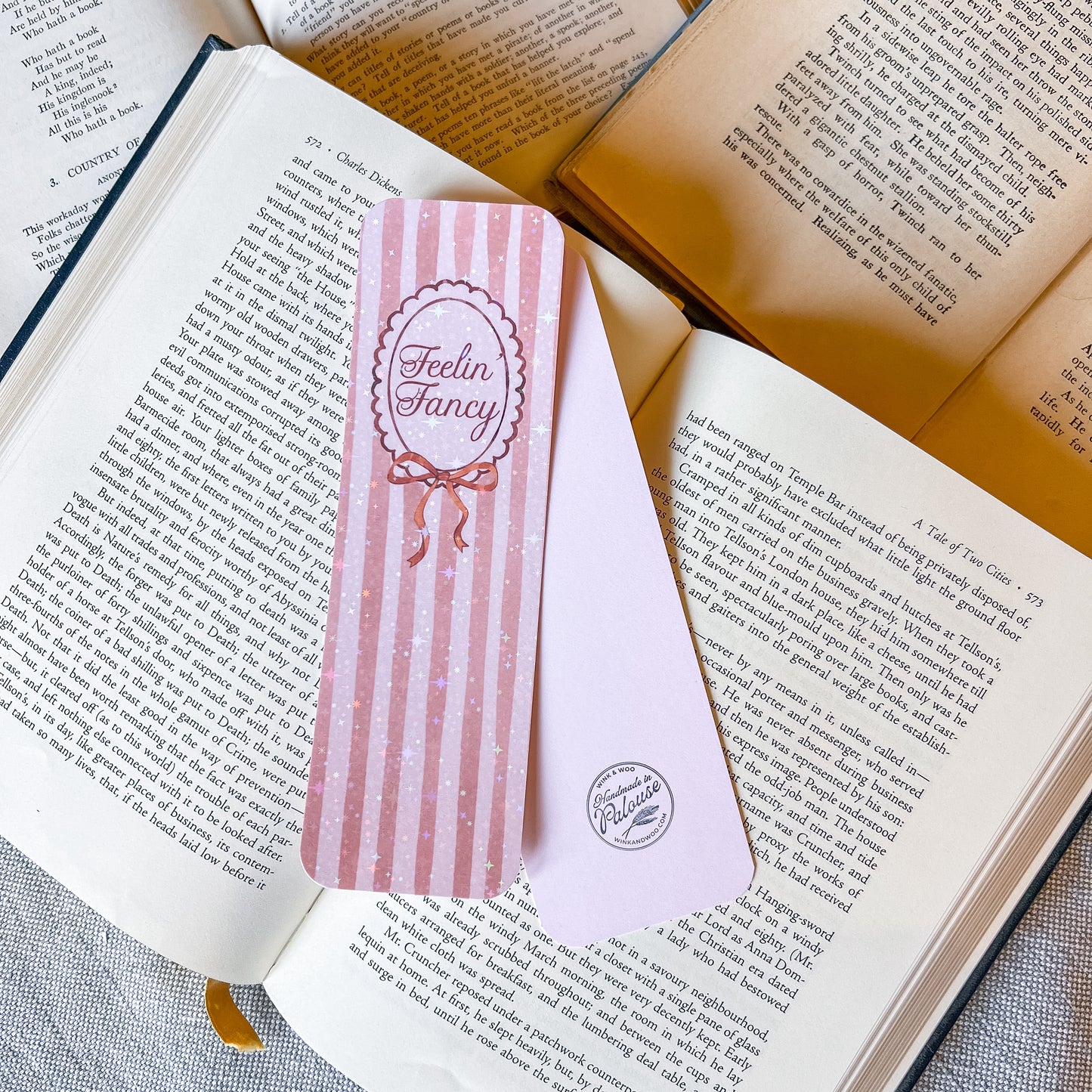 Pink striped bookmark with 'Feelin' Fancy' design on an open book
