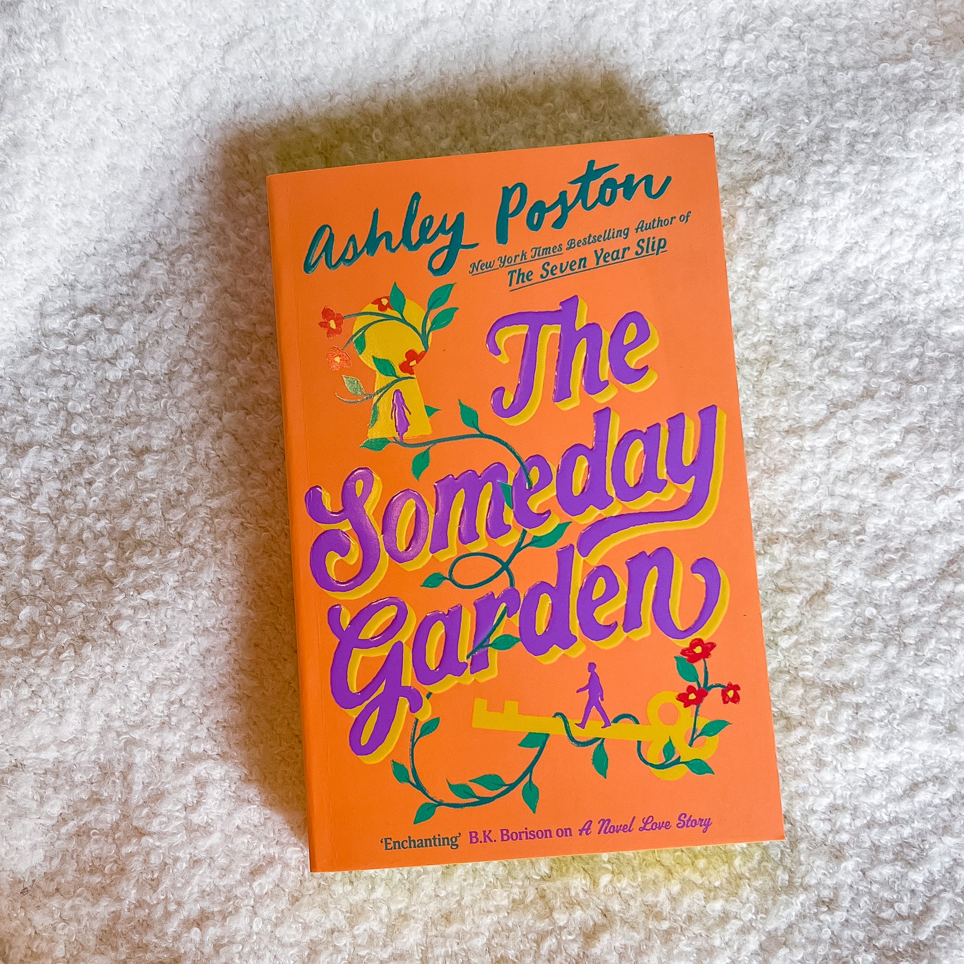 Book titled 'The Someday Garden' by Ashley Poston on a textured surface