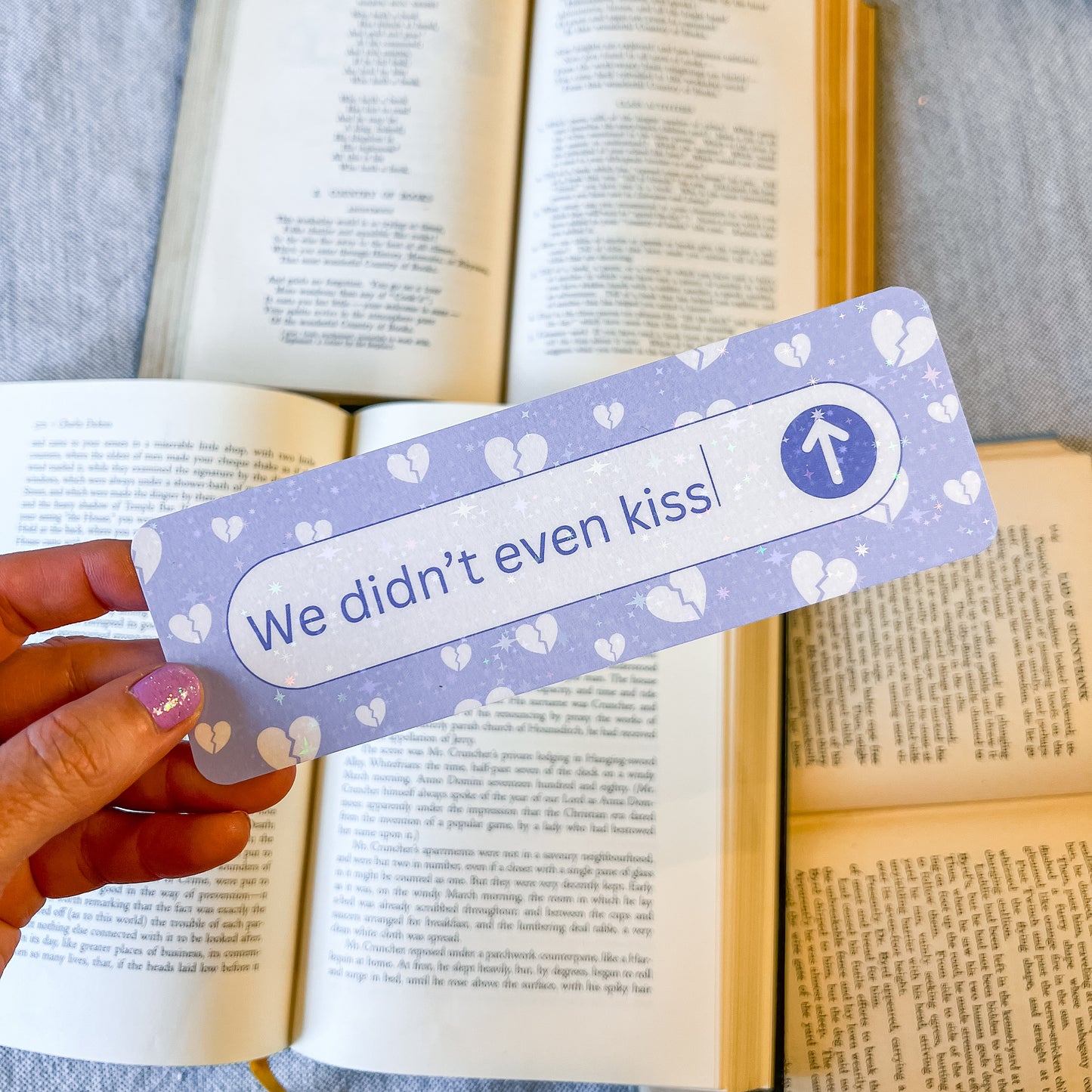 Bookmark with 'We didn't even kiss' text held over an open book