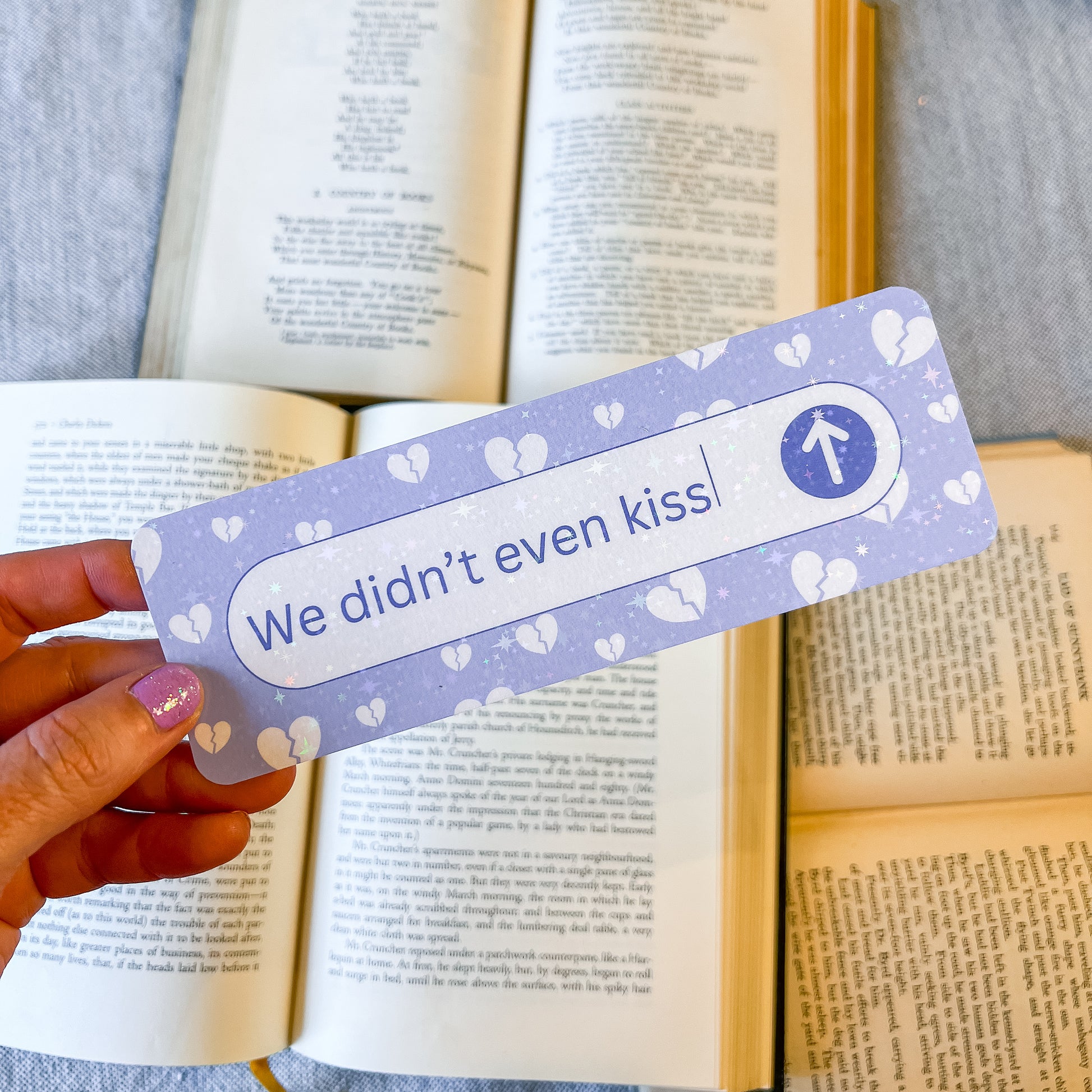 Bookmark with 'We didn't even kiss' text held over an open book