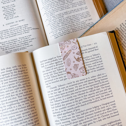 Open book with a decorative bookmark featuring nature-themed illustrations.