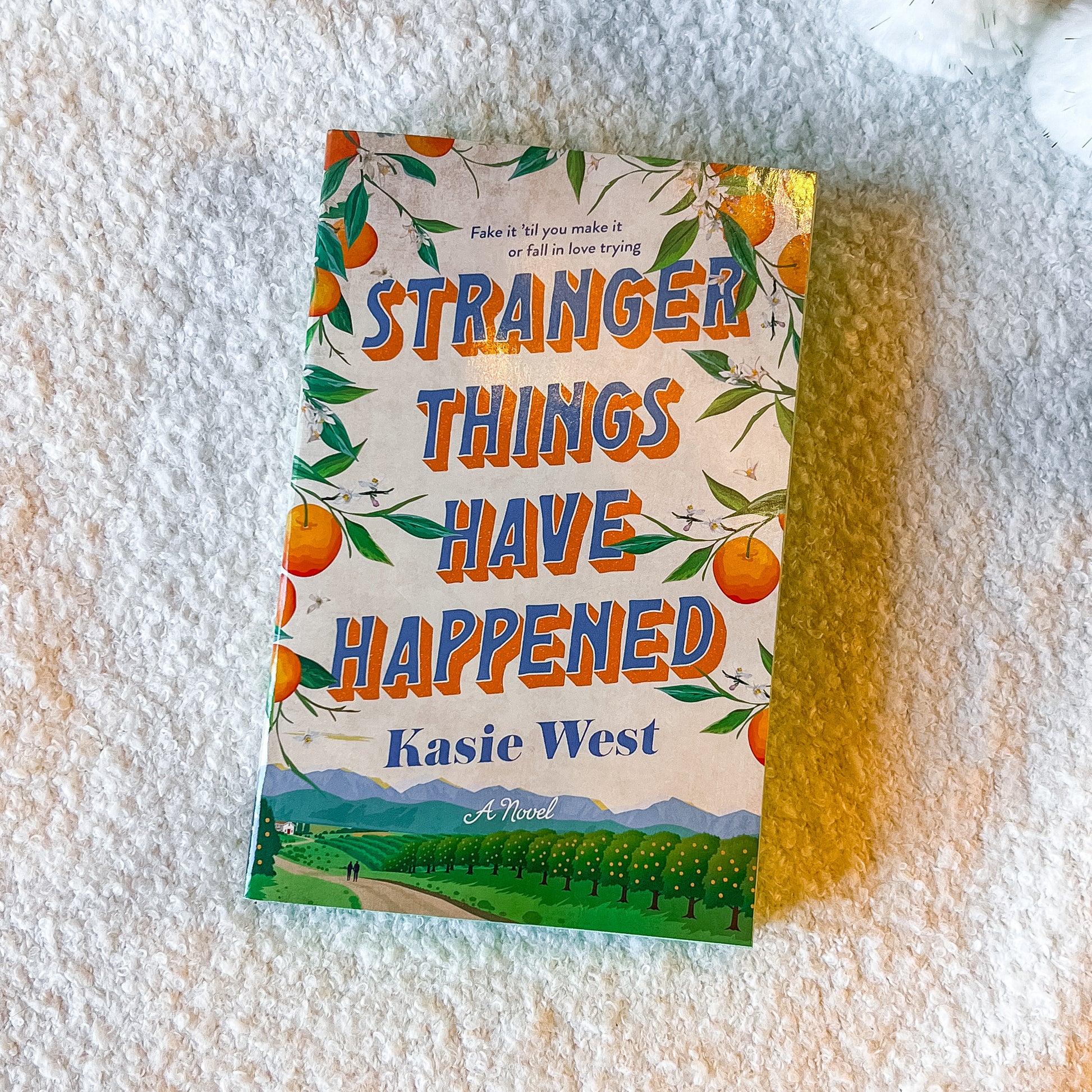 The book “stranger things have happened” with a rural design on a textured white surface