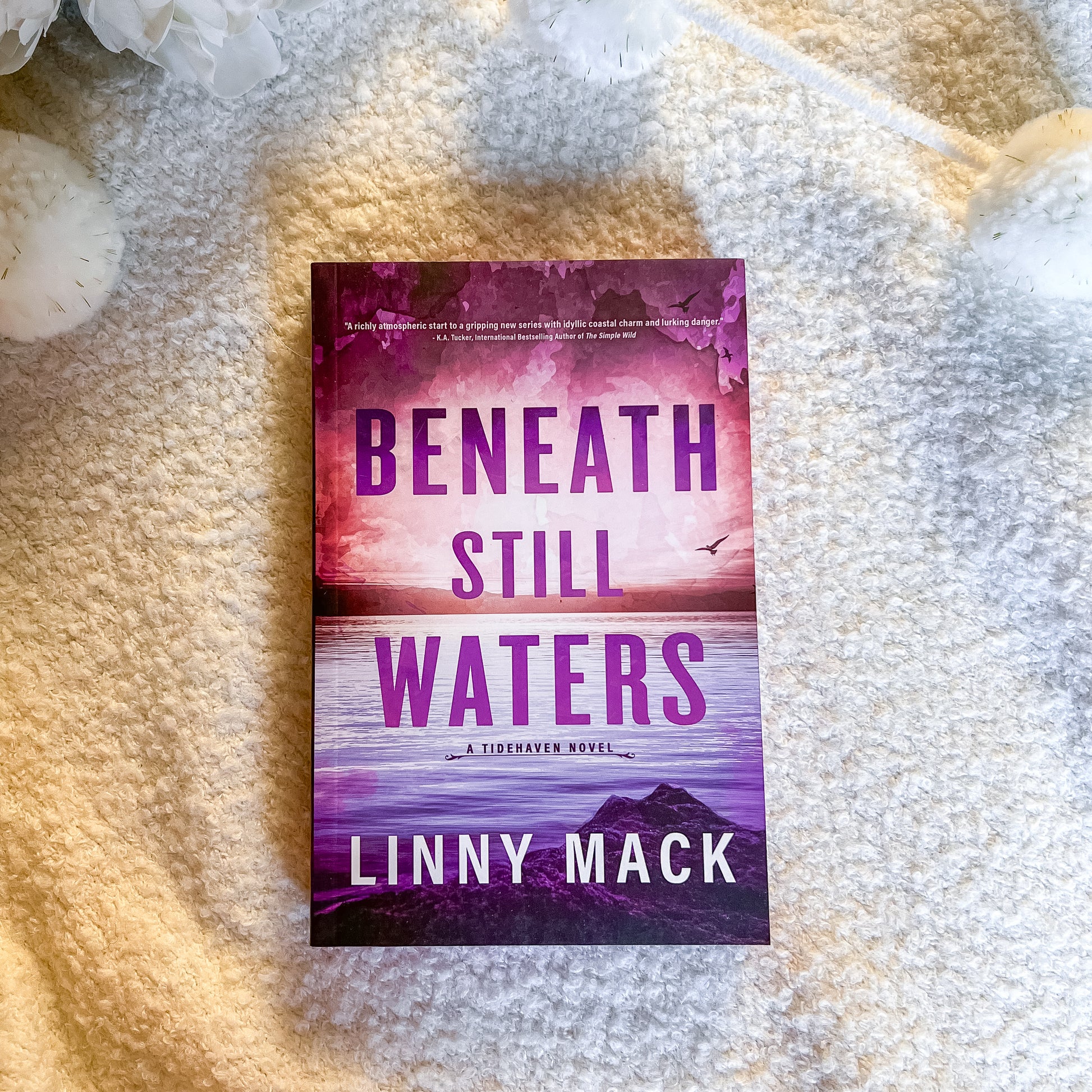 Book titled 'Beneath Still Waters' by Linny Mack on a textured surface