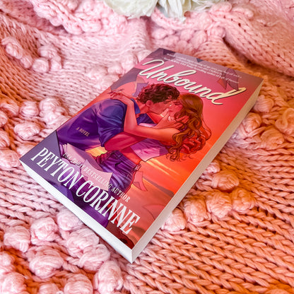 Book titled 'Unbound' by Peyton Corinne on a textured pink surface
