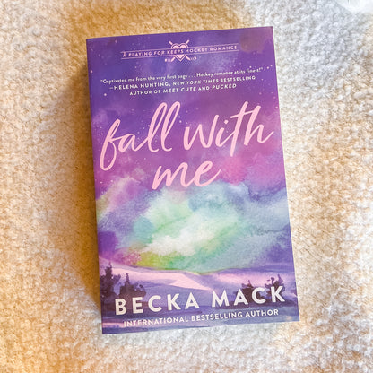 Book titled 'fall with me' by Becka Mack on a textured surface