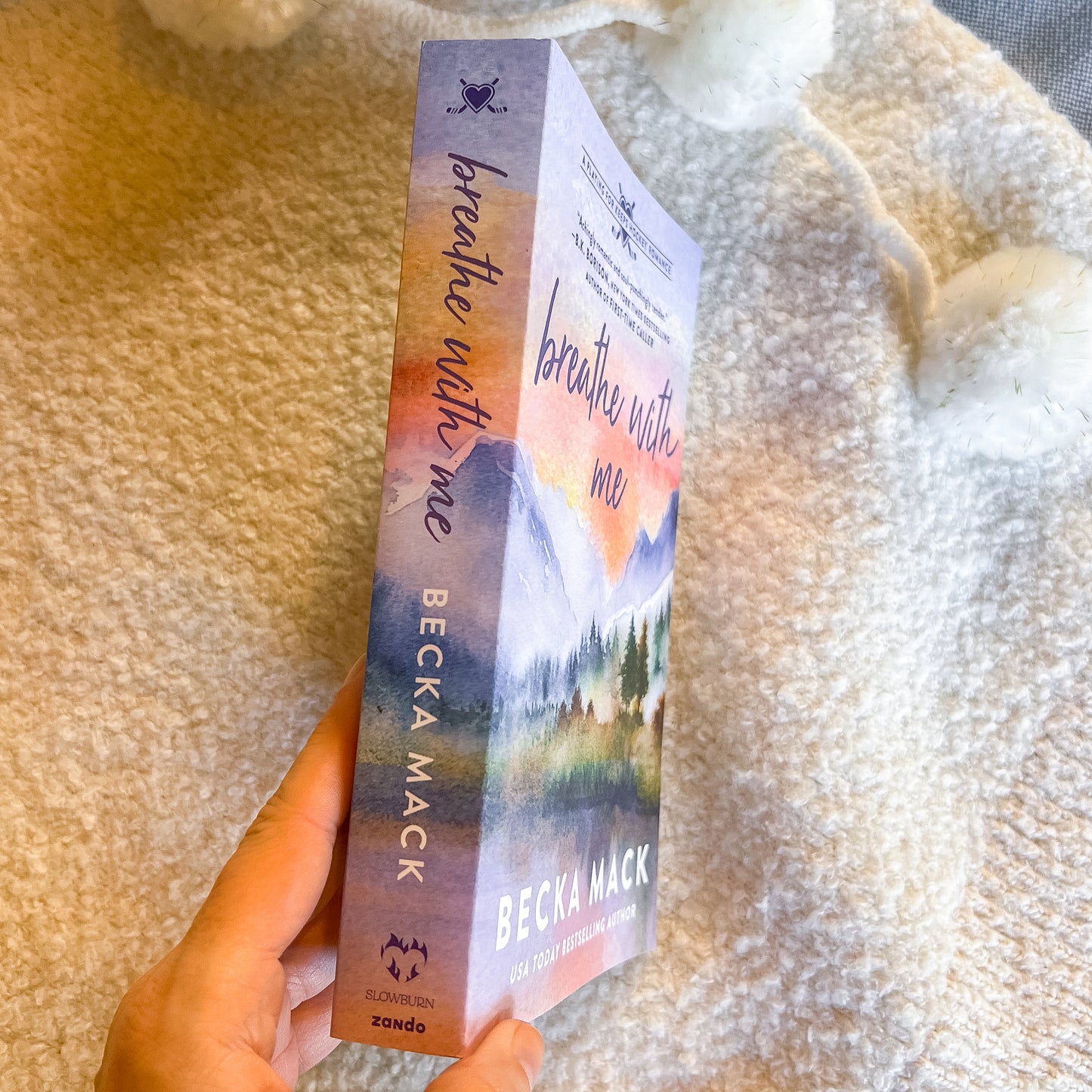 Book titled 'Breathe with Me' by Becka Mack held against a textured beige background