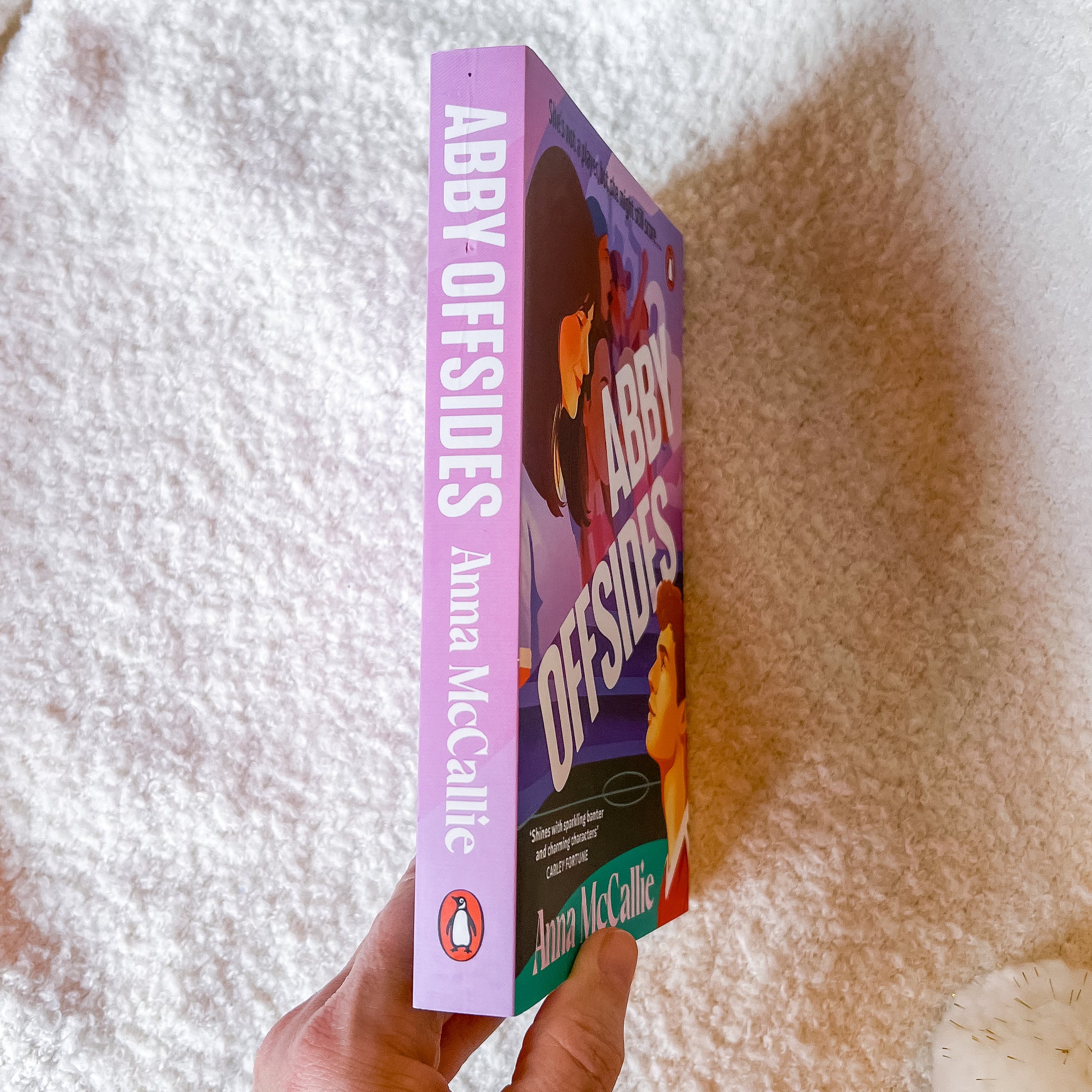 Book titled 'Abby Offsides' by Anna McCallie held against a textured white and brown background.
