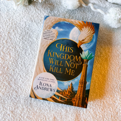 Book titled 'This Kingdom Will Not Kill Me' by Ilona Andrews on a textured surface.