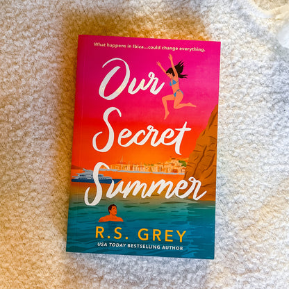 Book titled 'Our Secret Summer' by R.S. Grey on a textured surface