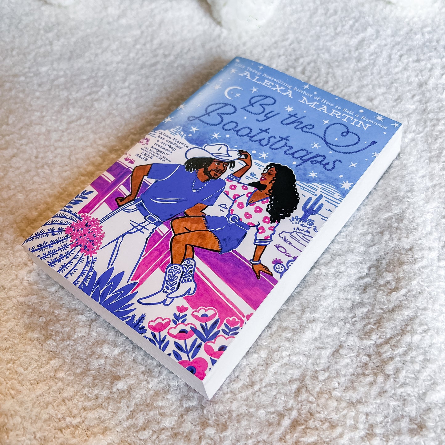 Book titled 'By the Bootstraps' by Alexa Martin on a textured surface