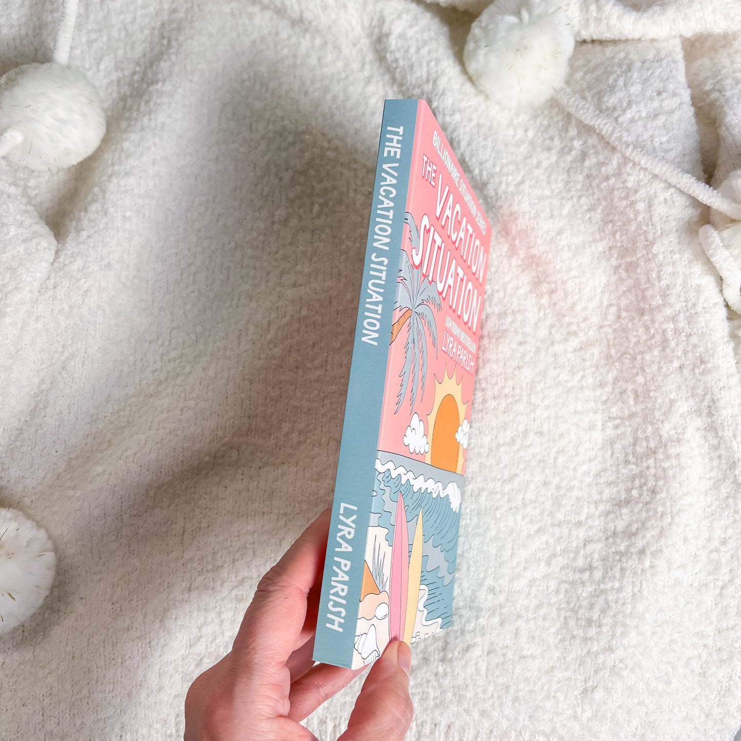 Book titled 'The Vacation Situation' held against a soft, white textured background