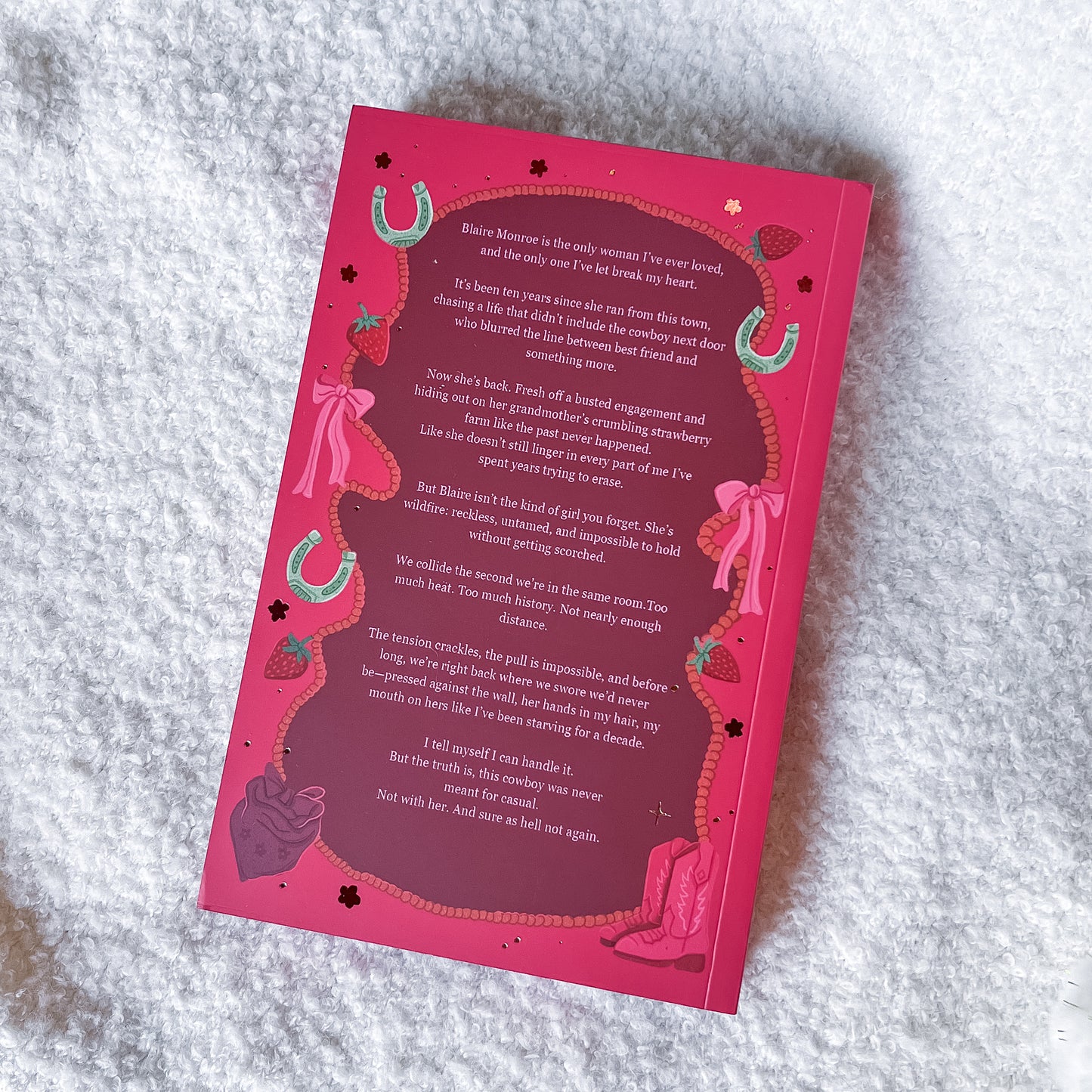 Pink book with decorative text on a textured surface