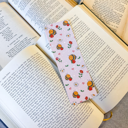 Book with a decorative bookmark featuring cartoon characters and flowers on an open book.