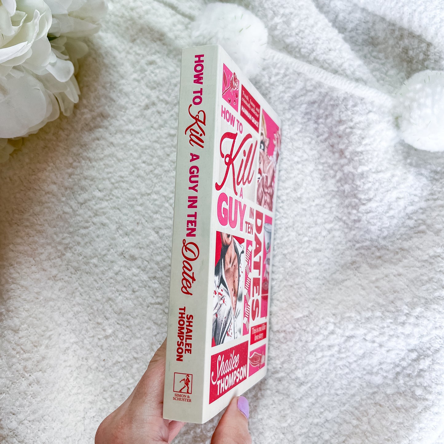 A hand holds a book titled "How to Kill a Guy in Ten Dates" by Shaillee Thompson. The book cover and spine feature a pink and red collage design with photos of a woman.