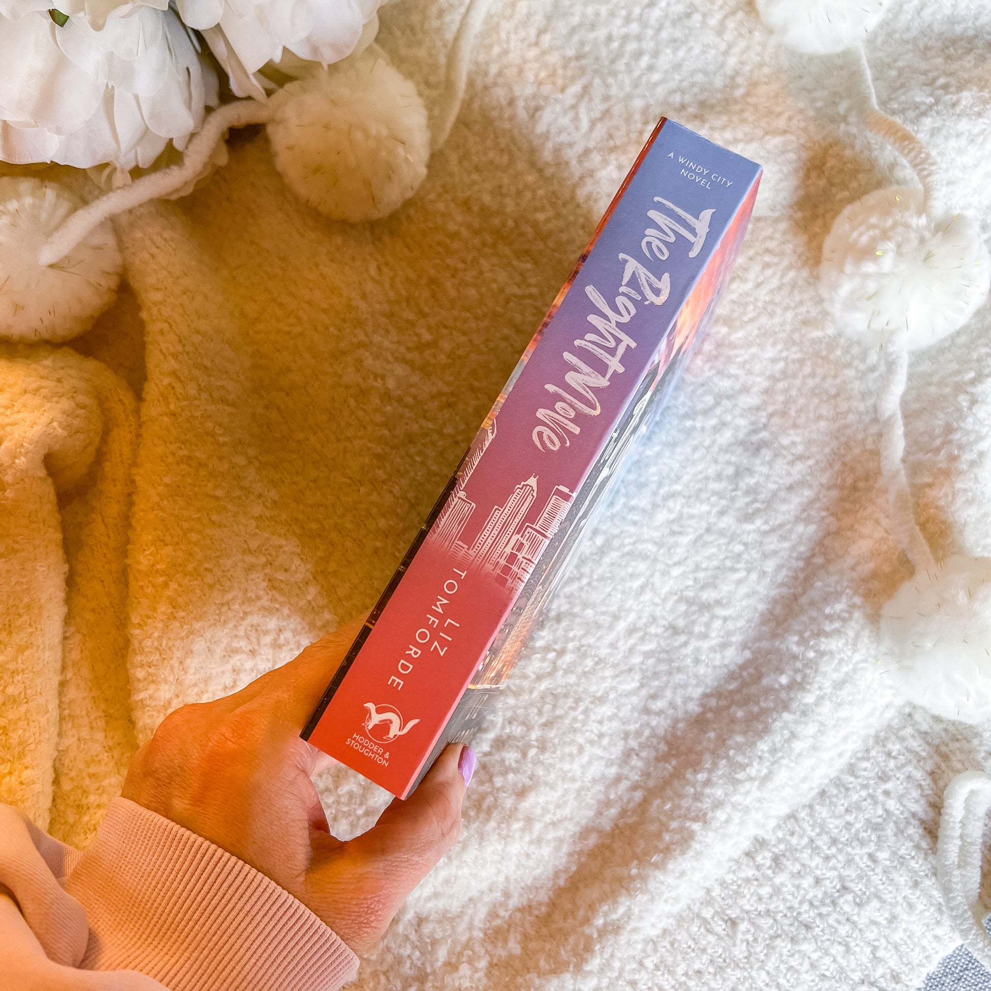 Hand holding The Right Move book spine on a textured surface with flowers in the background