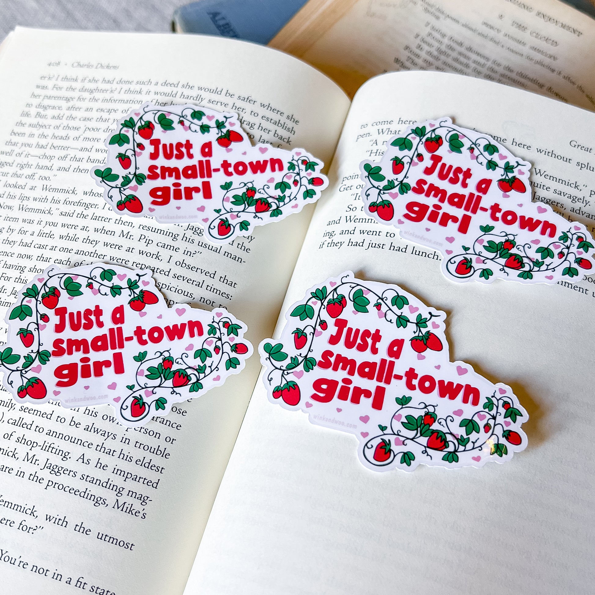 Four 'Just a small-town girl' stickers on an open book