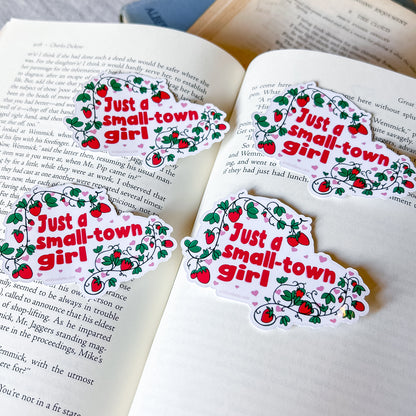 Four 'Just a small-town girl' stickers on an open book